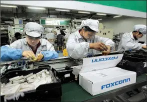  ?? AP ?? Employees work on the production line at the Foxconn Technology Group complex in the southern Chinese city of Shenzhen in this file photo. Foxconn officials have not responded to a claim by President Donald Trump that the company plans to spend $30...