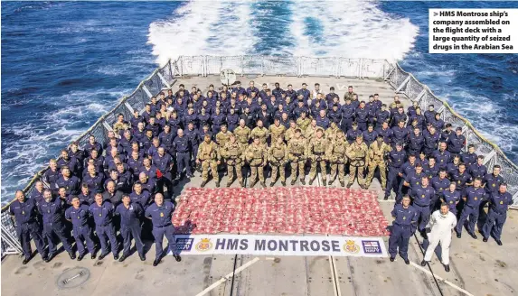  ?? AET Josh Edwards ?? > HMS Montrose ship’s company assembled on the flight deck with a large quantity of seized drugs in the Arabian Sea