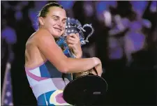  ?? DITA ALANGKARA/AP PHOTO ?? Aryna Sabalenka of Belarus hugs the Daphne Akhurst Memorial Trophy after defeating Elena Rybakina of Kazakhstan in the women’s singles final at the Australian Open on Saturday in Melbourne.