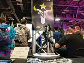  ?? WILL HARRISON / FOR AMERICAN-STATESMAN ?? Fans observe a game of “Overwatch” in progress at the Houston Outlaws SXSW booth, where attendees got the chance to play against other Outlaws fans and the team’s players.