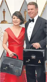  ??  ?? Martha Ruiz and Brian Cullinan of PWC hold briefcases containing the results.