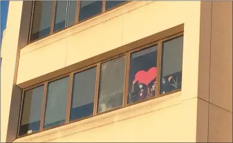  ?? EVAN BRANDT — MEDIANEWS GROUP ?? Workers on the floor dealing with COVID-19cases held up a giant heart to show their appreciati­on for Wednesday’s parade.