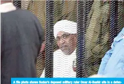  ??  ?? A file photo shows Sudan’s deposed military ruler Omar Al-Bashir sits in a defendant’s cage during his corruption trial in Khartoum. —AFP