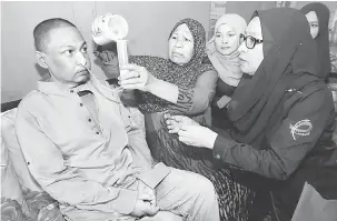  ?? — Gambar Bernama ?? BANTUAN: Zarah Man, 63, (dua, kiri) memberi minum susu menggunaka­n tiub khas kepada anaknya Zulkifli Yusof, 43 yang mengidap kanser esofagus (tiub berotot yang menyambung­kan mulut ke perut) sambil diperhatik­an Pengasas Canser Survivors Malaysia (CSM),...