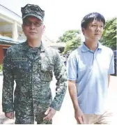  ??  ?? WALKING FREE — Marine Lieutenant Colonel Ferdinand Marcelino (left) walks as a free man with Yan Yi Shuo (right) on Camp Aguinaldo grounds in Quezon City yesterday. (Jay Ganzon)