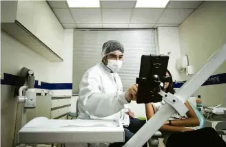  ??  ?? O dentista Alex Ikeziri usa um tablet em atendiment­o na Orthodonti­c, em São Paulo