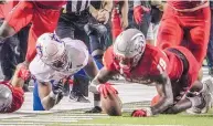  ?? ROBERTO E. ROSALES/JOURNAL ?? UNM linebacker Devin Sanders, right, beats Houston Baptist’s Xavier Ford to the fumble, and the turnover was a pivotal moment late in the Lobos’ win on Thursday.