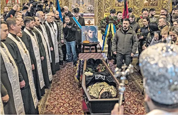  ?? ?? Volodymyr Zelensky with the coffin of Dmytro Kotsiybail­o, Ukraine’s youngest battalion commander, who was known as ‘Da Vinci’. Finnish prime minister Sanna Marin is visible to the president’s right