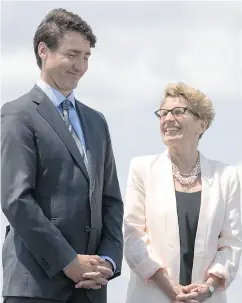  ?? CHRIS YOUNG / THE CANADIAN PRESS ?? Prime Minister Justin Trudeau flanks Ontario Premier Kathleen Wynne during a funding announceme­nt for the Toronto waterfront on Wednesday.
