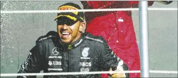  ?? FERNANDO LLANO/AP ?? SECOND PLACED MERCEDES DRIVER LEWIS HAMILTON of Britain (bottom) is sprayed with champagne by third placed Ferrari driver Charles Leclerc of Monaco on the podium for the Formula One Mexico Grand Prix auto race at the Hermanos Rodriguez racetrack in Mexico City on Oct. 29, 2023.