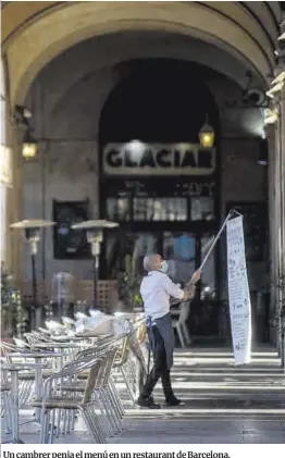  ?? Jordi Cotrina ?? Un cambrer penja el menú en un restaurant de Barcelona.