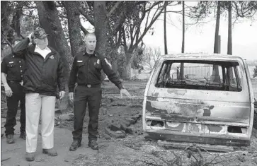  ??  ?? NICK SCHULER, deputy chief of the California Department of Forestry and Fire Protection, guides Trump through a Malibu neighborho­od razed by the Woolsey fire. The president said he would help California “100%.”