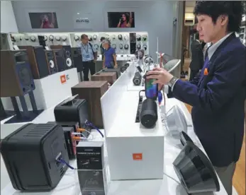  ?? TOMOHIRO OHSUMI / BLOOMBERG ?? A Harman employee handles a JBL Pulse wireless speaker in a company store in Tokyo, Japan.