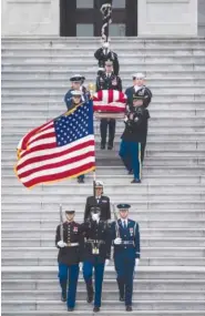  ?? (SARAH SILBIGER/THE NEW YORK TIMES VIA AP, POOL) ?? Left: Bush’s flag-draped casket of is carried by a joint services military honor guard down the steps of the U.S. Capitol on Wednesday.