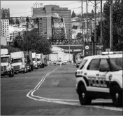  ?? ASSOCIATED PRESS ?? A POLICE OFFICER guards the front of a road block near the Northwest Detention Center Saturday in Tacoma, Wash.