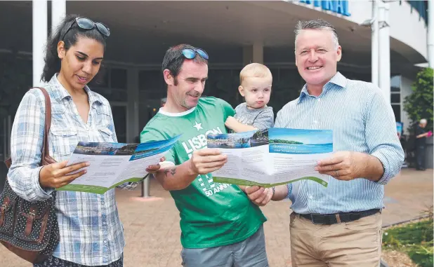  ?? Picture: BRENDAN RADKE ?? EYECATCHER: Cairns MP Michael Healy looks over details of the proposed Global Tourism Hub with Cairns residents Narrelle, Brian and Rudy Mullen.