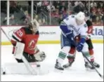  ?? BILL KOSTROUN — THE ASSOCIATED PRESS ?? Devils goaltender Mackenzie Blackwood (29) makes a save as Devils defenseman Will Butcher (8) checks Vancouver Canucks center Bo Horvat (53) during Monday’s game in Newark.