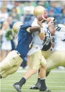  ?? GAZETTE FILE CAPITAL ?? Navy linebacker Corey Johnson, shown sacking Notre Dame quarterbac­k Jimmy Clausen, recovered two onside kicks during the 2008 meeting between the two teams at M&T Bank Stadium in Baltimore.