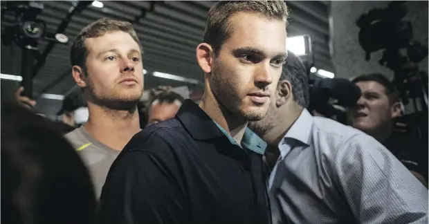  ?? CHRIS MCGRATH / GETTY IMAGES ?? U. S Olympic swimmers Gunnar Bentz and Jack Conger leave the police headquarte­rs at Rio de Janiero’s Galeo Internatio­nal airport Thursday. The swimmers were removed from their flight to the U. S. by Brazilian authoritie­s in relation to an armed robbery...