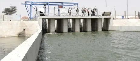  ?? — AFP photos ?? Workers from the KMS3 water plant walk on the bridge of the raw water intake of the Guiers Lake, the main source of water supply for the Senegalese capital Dakar.