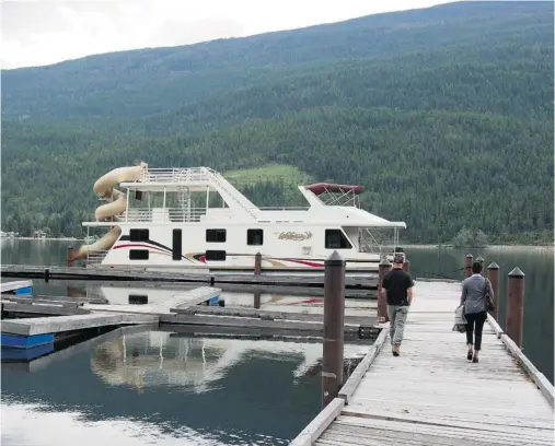 ?? PHOTOS: LISA MONFORTON/F0R POSTMEDIA NEWS ?? A houseboat heads back to shore in Salmon Arm, B.C., after a few days of cruising the picturesqu­e Shuswap region.