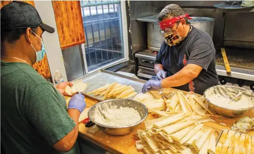  ?? ANTHONY VAZQUEZ/SUN-TIMES ?? Owner Claudi Velez (right) and an employee prepare tamales on Tuesday at Tamale Guy Chicago in Ukrainian Village.