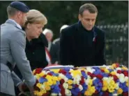  ?? AP PHOTO — MICHEL EULER ?? French President Emmanuel Macron, right, and German Chancellor Angela Merkel lay a wreath of flowers during a ceremony in Compiegne, north of Paris, Saturday. The leaders of France and Germany have held an intimate commemorat­ion at the site north of Paris where the vanquished Germans and victorious but exhausted Allies put an end to World War I.