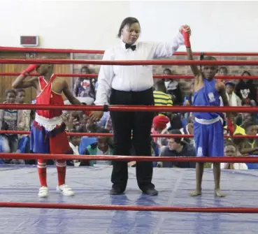  ?? Leonard Solms Photo: ?? Athenkosi Qeqe, from Goodwood Boxing Club in Veeplaas, Port Elizabeth (red) and Ahlumile Adam of Phakamisa Boxing Club from Peddie (blue) with referee Manzozuko Mofu from Queenstown.