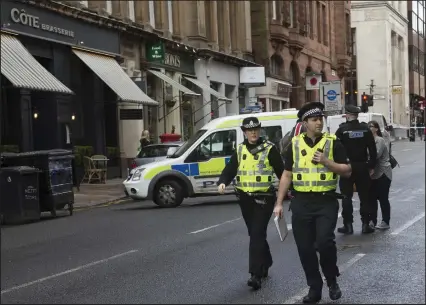  ??  ?? Police officers seal off West Nile Street after a man went on a horrific knife rampage – he later died of his injuries