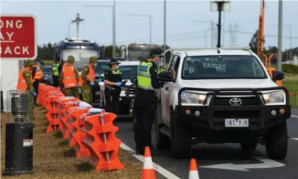  ??  ?? Victorian police and Australian defence force personnel manage roadside checkpoint­s near Donnybrook on Wednesday to enforce coronaviru­s travel restrictio­ns. Photograph: James Ross/EPA