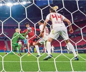  ?? AFP PIC ?? Liverpool’s Mohamed Salah (second from left) and Leipzig goalkeeper Peter Gulacsi (left) vie for the ball in Wednesday’s Champions League match at the Puskas Arena in Budapest.