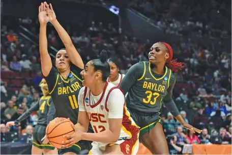  ?? AP PHOTO/STEVE DYKES ?? Southern California freshman JuJu Watkins looks to shoot as Baylor guards Jada Walker (11) and Aijha Blackwell defend during the first half of their NCAA tournament Sweet 16 game Saturday in Portland, Ore.