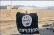  ??  ?? An Iraqi soldier displays an Islamist State flag after a military operation in Al-Qasar near Mosul in November. REUTERS FILE