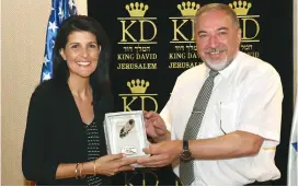  ?? (Matty Stern/US Embassy Tel Aviv) ?? US AMBASSADOR to the UN Nikki Haley receives a gift from the defense minister on Friday. Under the miniature high-heeled shoe, a reference to her speech at AIPAC’s policy conference in March, is written: ‘To the UN’s new sheriff. Respectful­ly, Avigdor...