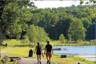  ?? MICHILEA PATTERSON — DIGITAL FIRST MEDIA ?? People walk along a path at Green Lane Park in Montgomery County. Like many areas in the region, the park boasts lake areas and trails that can be used for several recreation­al opportunit­ies.