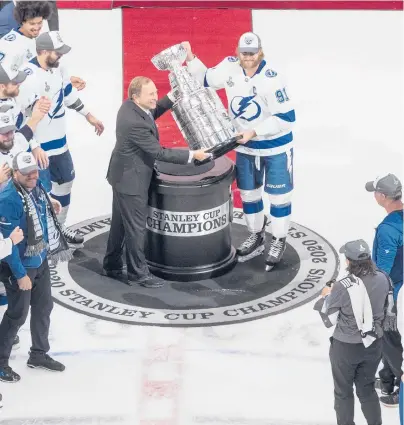  ?? JASON FRANSON/AP ?? Lightning’s Steven Stamkos is presented the Stanley Cup from NHL commission­er Gary Bettman on Sept. 28 in Edmonton.