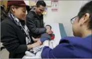  ?? TED S. WARREN — THE ASSOCIATED PRESS ?? Matilde Gonzalez, left, and Cesar Calles, hold their son, Cesar Julian Calles, 10-months old, as Ana Martinez, a medical assistant at the Sea Mar Community Health Center, gives him a flu shot Thursday in Seattle.