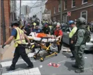  ??  ?? Rescue personnel help injured people after a car ran into a large group of protesters after an white nationalis­t rally in Charlottes­ville, Va., Saturday, Aug. 12, 2017.