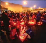  ?? SERGEI VEDYASHKIN — MOSCOW NEWS AGENCY VIA AP ?? People light candles and lay flowers at a makeshift memorial in front of the Crocus City Hall on the western outskirts of Moscow, Russia, on Sunday. There were calls Monday for harsh punishment for those behind the attack on the Russia concert hall that killed more than 130 people as authoritie­s combed the burnt-out ruins of the shopping and entertainm­ent complex in search of more bodies.