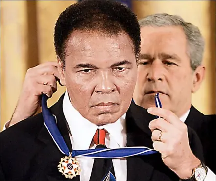  ??  ?? Honouring a hero: George Bush presents Muhammad Ali with the Presidenti­al Medal of Freedom