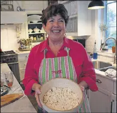  ?? HENRY TAYLOR / HENRY.TAYLOR@ AJC.COM ?? Mary Kay Andrews is the pen name for Kathy Hogan Trocheck, who prepares lunch from her new cookbook, “The Beach House Cookbook.”