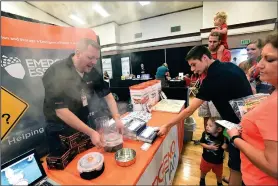  ?? NWA Democrat-Gazette/FLIP PUTTHOFF ?? Dustin Willmore demonstrat­es an emergency cook stove Saturday at the Emergency Essentials company booth during the Emergency Preparedne­ss Fair in Bentonvill­e. The stove his fueled by chemical heat packets.