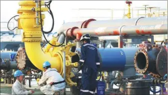  ?? ZHUANG BEINING / XINHUA ?? Workers connect a conduit to the 140,000-ton crude tanker to unload oil at Made Island oil port in Myanmar on Monday. Crude oil will then be transporte­d to China via the China-Myanmar crude oil pipeline.