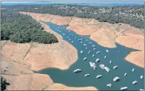  ?? JUSTIN SULLIVAN — GETTY IMAGES ?? Houseboats are dwarfed by the banks of Lake Oroville in April. The state is enduring a drought emergency with water levels dropping in the state’s reservoirs.