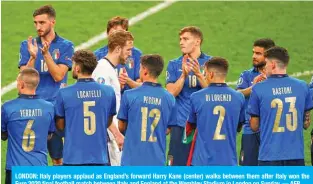  ??  ?? LONDON: Italy players applaud as England’s forward Harry Kane (center) walks between them after Italy won the Euro 2020 final football match between Italy and England at the Wembley Stadium in London on Sunday. — AFP