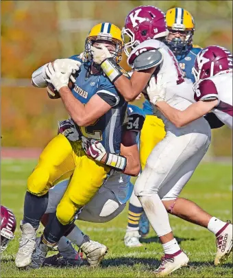  ?? SEAN D. ELLIOT/THE DAY ?? Killingly’s Evan DeRonsie (10) grabs the face mask of Ledyard’s Ben Askew (22) as Jonathan Rodriguez Mendez (54) brings Askew down during Saturday’s game at Bill Mignaulf Field in Ledyard. The Red Hawks remained unbeaten with a 55-22 win over the Colonels.