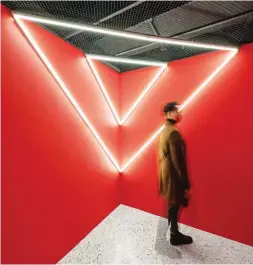  ??  ?? Opposite: At display alcoves, fragmented forms wrap columns that have been stripped bare revealing the red horizontal structural braces. Above: Fluorescen­t light installati­ons in the fitting room were designed as the ultimate selfie backdrops.