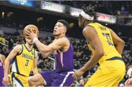  ?? DARRON CUMMINGS AP ?? The Suns’ Devin Booker goes to the basket against the Pacers’ Myles Turner (33) during the second half of a 112-94 victory for Phoenix at Indiana on Friday night.