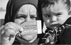  ??  ?? A Palestinia­n woman shows her World Food Programme (WFP) ration card in Yatta, a village near Hebron in the occupied West Bank. — AFP photo