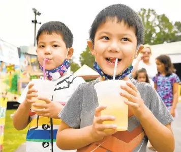  ?? PAUL W. GILLESPIE/CAPITAL GAZETTE PHOTOS ?? Siblings Alec Wang, 5, and Aiden Wang, 5, drink lemonade Thursday at the Anne Arundel County Fair.